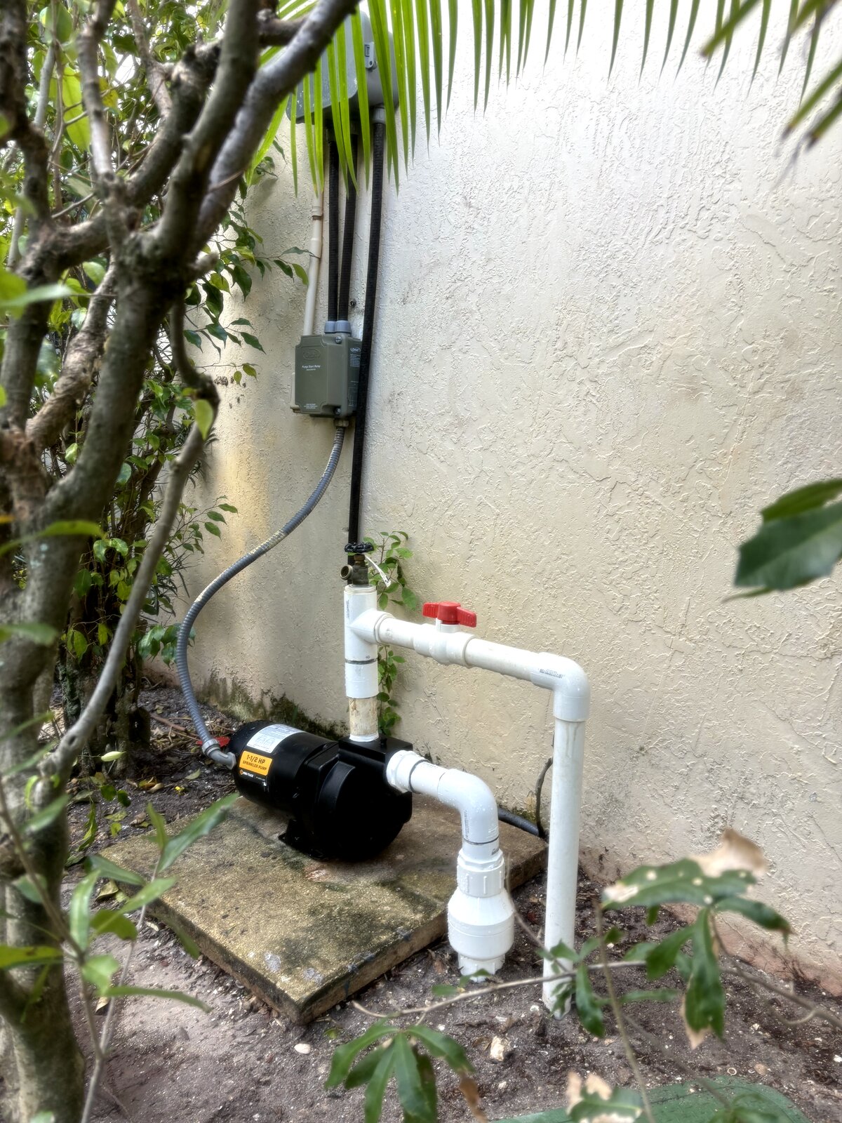 new irrigation pump installed on stucco wall at Miami home after repair
