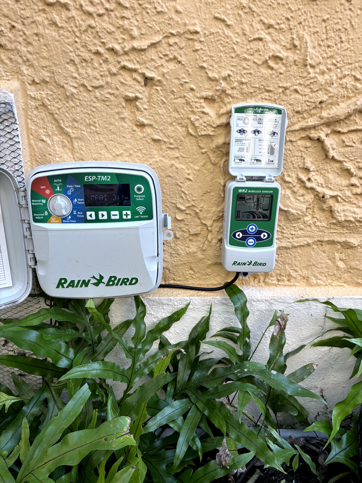 Rain Bird WR2 wireless rain sensor installed on a Miami home eave