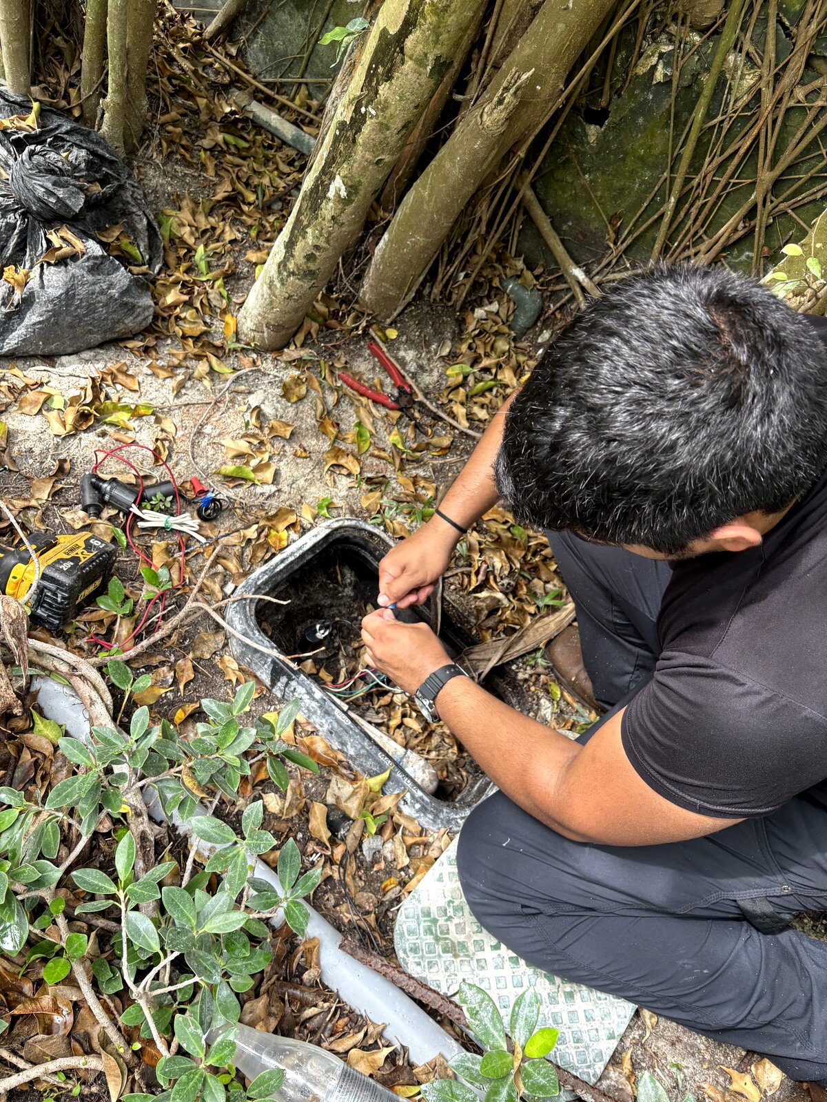 irrigation technician repairing sprinkler system at Miami home